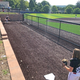 Lily Woodworth of Connecticut warms up in the pen with catcher Maggie Foxx of New Hampshire.